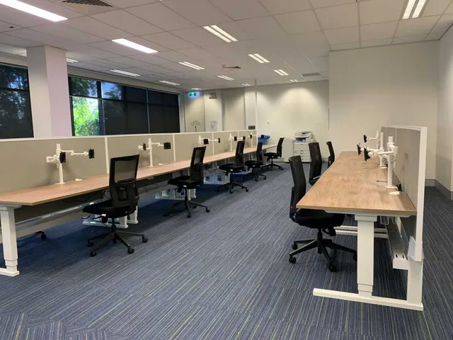 Office workstations with custom screens and ergonomic chairs